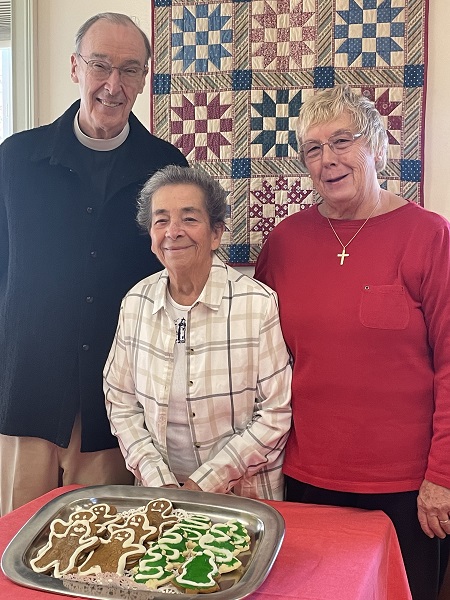 three people with christmas cookies